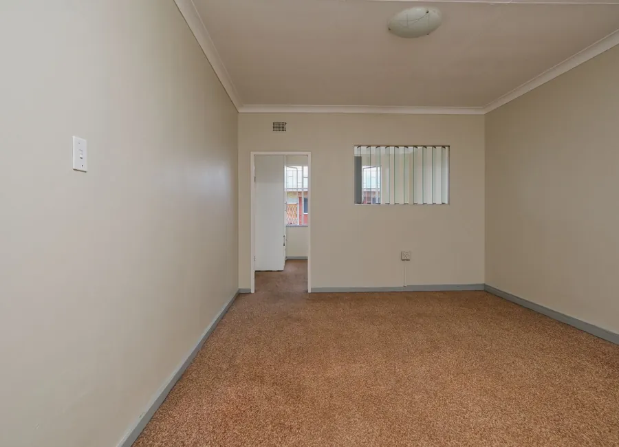 Spacious empty room featuring carpet flooring and neutral walls. Ideal for real estate listings.