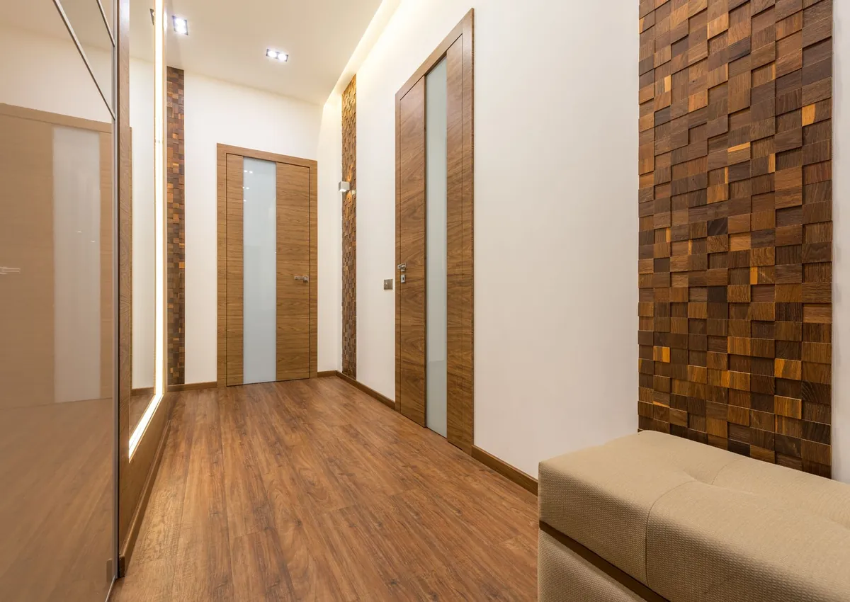 Contemporary hallway featuring wooden doors, parquet flooring, and stylish wall design.