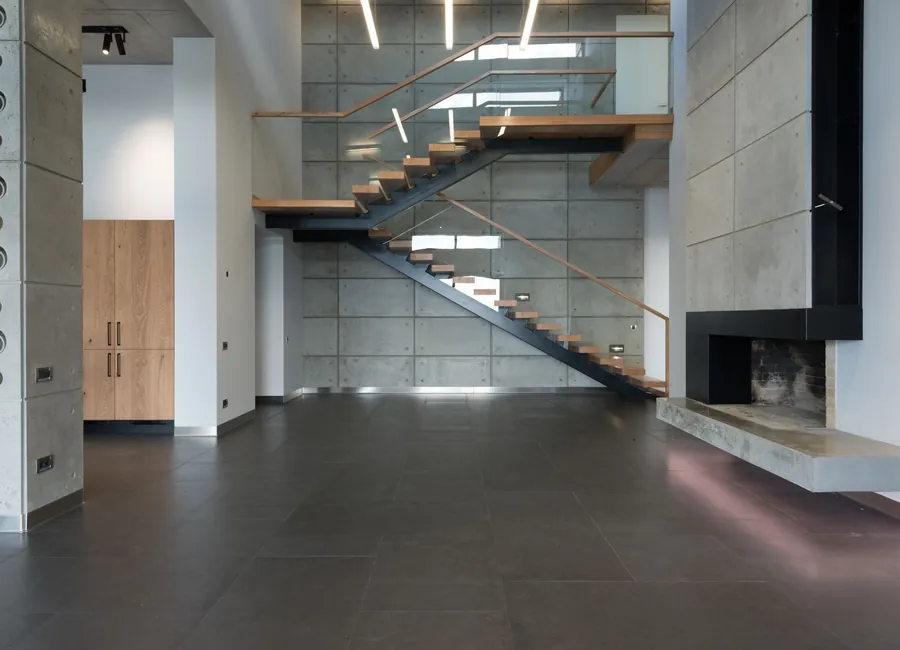 Interior of spacious tiled apartment with staircase with wooden steps leading to second floor